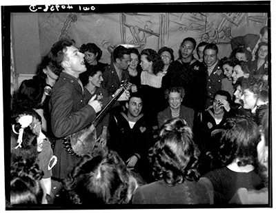 Washington, D.C. Pete Seeger, noted folk singer entertaining at the opening of the Washington labor canteen, sponsored by the United Federal Labor Canteen, sponsored by the Federal Workers of American, Congress of Industrial Organizations (CIO)